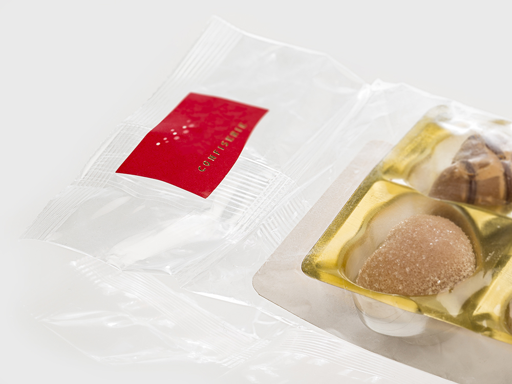 Abbildung von Pralinen in Flowpack-Verpackung mit Header und Label